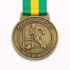 A round bronze Rugby League Cup 2026 Winners medal featuring a rugby player running with the ball in front of goalposts, with raised detailing and a green and yellow ribbon.