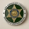 Los Angeles County Sheriff's Department badge displayed alongside challenge coins, symbolizing law enforcement pride and service.
