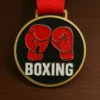 A boxing medal featuring a design of boxing gloves prominently displayed on its surface.