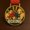 A boxing medal resting on a wooden table, showcasing its shiny surface and intricate design.
