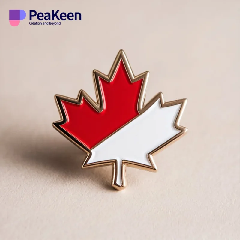 Red and white maple leaf pin on a white background, symbolizing Canada.