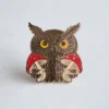 Owl enamel pin featuring an owl holding a mushroom, showcasing a whimsical and colorful design.