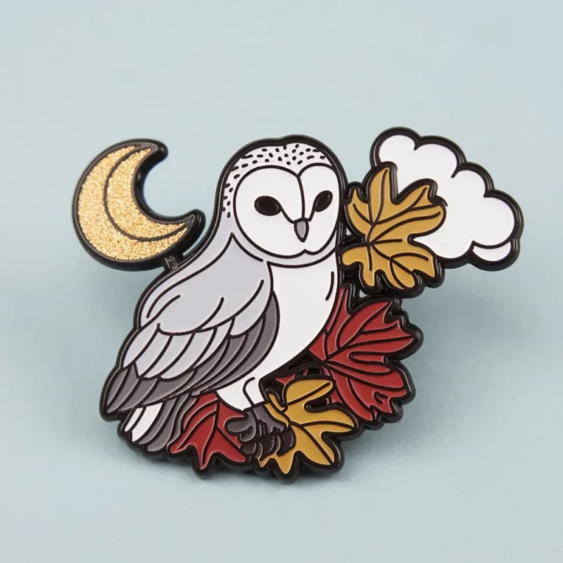 A charming owl enamel pin adorned with stylized leaves.