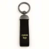 Black leather keychain featuring the words "custom logo," showcasing genuine leather craftsmanship.