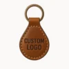 Genuine leather keychain featuring the words "custom logo" embossed on its surface.