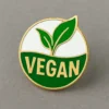 Green leaf icon with the word "vegan" on a circular badge design.