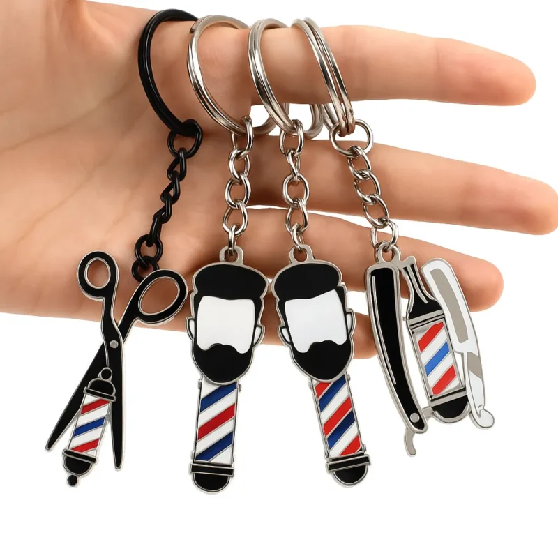 A hand displays a barber keychain adorned with small scissors and barber scissors, emphasizing a hairstyling theme.