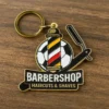 Barber shop keychain with a pin design, highlighting classic barber tools like scissors and a comb for hair care.