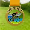 A gold cycling medal featuring the text "custom text" engraved on its surface.