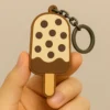 A hand holds a colorful ice cream popsicle keychain, showcasing its fun design and vibrant colors.