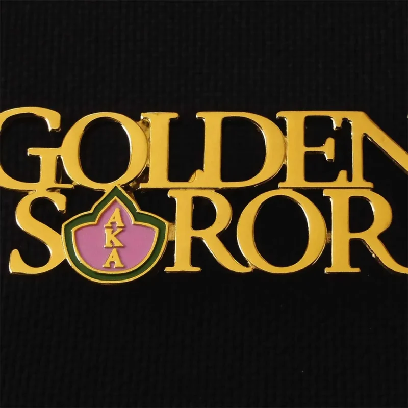 Golden soror lapel pin, also known as an aka pin, symbolizing sisterhood and unity among members.