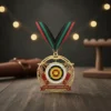 A medal with a red, green, and black ribbon rests on a wooden table, representing an archery target achievement.