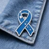 Blue awareness ribbon enamel pin with star accents displayed on a denim jacket, symbolizing support for health awareness and charity causes.