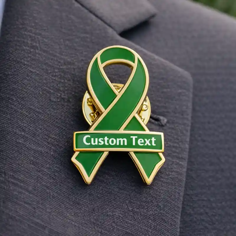 Green awareness ribbon enamel pin with gold outline and custom text, worn on a suit jacket to represent support for health awareness and social causes.