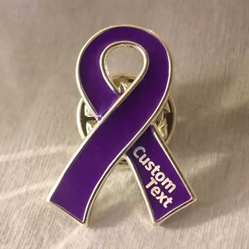 Close-up of a purple awareness ribbon enamel pin with silver edge and custom text, symbolizing cancer awareness and support.