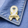 Customizable white awareness ribbon enamel pin with personalized text, displayed on denim fabric, representing support for general causes or charity events.