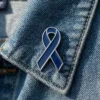 Dark blue awareness ribbon enamel pin displayed on a denim jacket, symbolizing support, awareness, and solidarity.