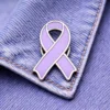 A lavender enamel ribbon pin with silver edges, attached to a denim jacket.