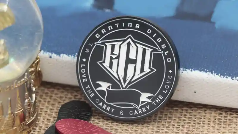 Moneda de colección en blanco y negro con el logotipo de FCH en el centro. El borde negro lleva inscrito el texto "EL CANTINA DIABLO" y "LOVE THE CARRY & CARRY THE LOVE".