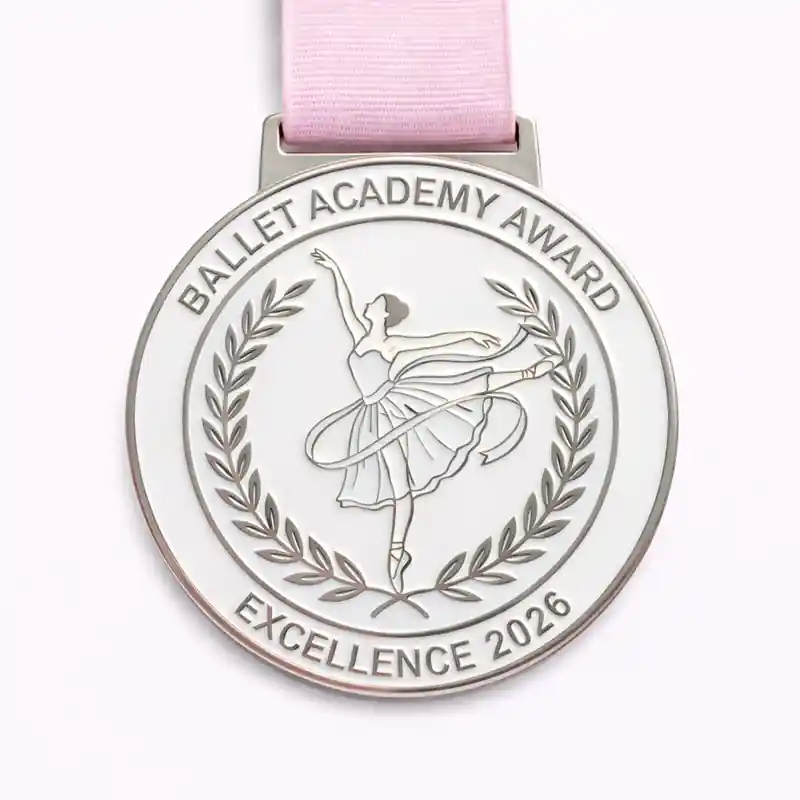 A silver ballet academy award medal with a dancer in mid-pose, surrounded by a laurel wreath. The inscription reads "BALLET ACADEMY AWARD" at the top and "EXCELLENCE 2026" at the bottom.
