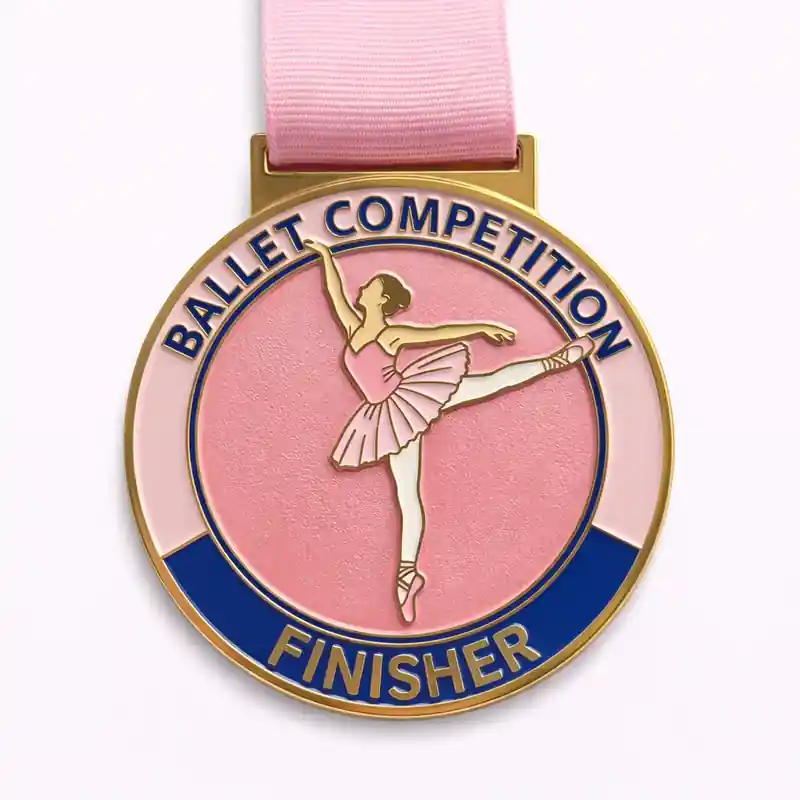 A gold Ballet Competition Finisher medal with a pink background, featuring a ballerina in mid-pose, suspended from a pink ribbon.