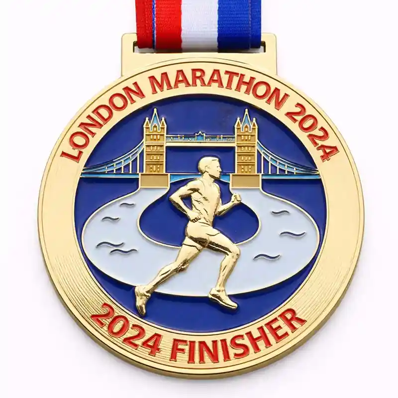 A gold medal with a design featuring Tower Bridge and a runner in motion, with the inscription "LONDON MARATHON 2024" and "2024 FINISHER" at the bottom, along with a red, white, and blue ribbon attached.