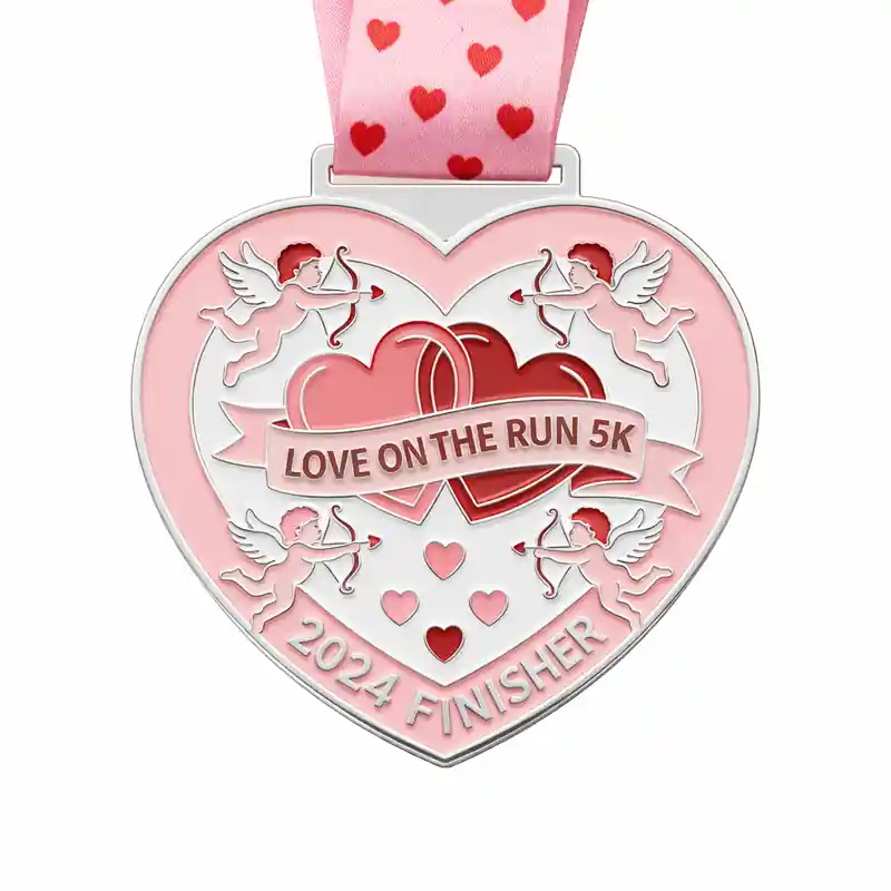 A heart-shaped silver medal featuring two hearts intertwined, with Cupid's arrows and the inscription "LOVE ON THE RUN 5K 2024 FINISHER" along with a pink ribbon decorated with heart patterns.