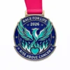 A medal featuring a phoenix rising from flames, with teal and blue wings and a heart at the base. The top of the medal reads "RACE FOR LIFE 2026" and the bottom reads "RISE ABOVE CANCER."