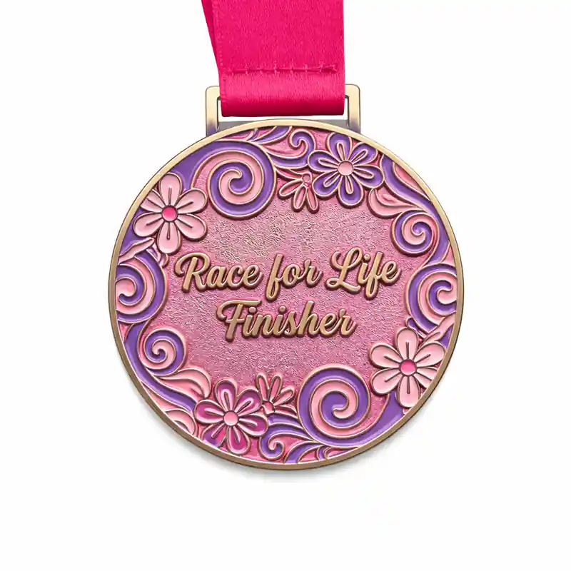 A round medal with a pink and purple floral design, featuring the words "Race for Life Finisher" in gold at the center. The medal is attached to a pink ribbon.