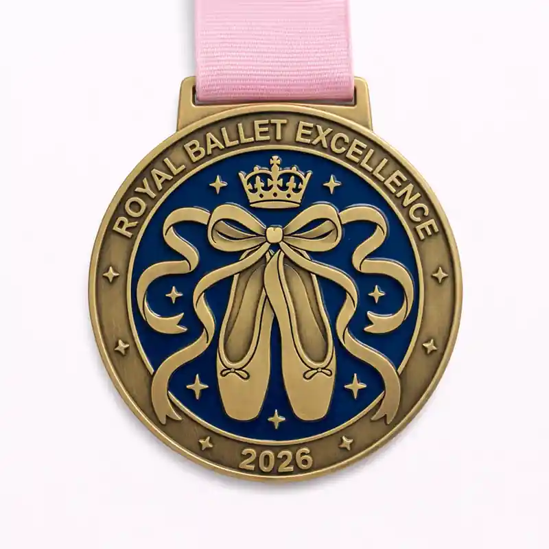 A royal ballet excellence medal featuring ballet slippers tied with a ribbon, a crown at the top, and stars around the border. The medal is inscribed with "ROYAL BALLET EXCELLENCE" and the year "2026."