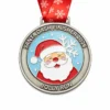 A round medal featuring a smiling Santa Claus with a red hat and white beard, with snowflakes in the background, and the inscription "SANTA DASH FINISHER 2026" and "JOLLY RUN" at the bottom, along with a red ribbon adorned with snowflakes.