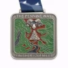 A silver medal for the Pennine Way 268 Miles featuring a design with a ram's head above a stone cairn, surrounded by a map-like pattern of green and brown terrain. A winding river flows from the cairn through the landscape. The medal is inscribed with "THE PENNINE WAY" and "FINISHER - 268 MILES," with a dark blue ribbon featuring a bird design.