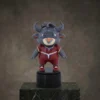 Figurine trophée de mascotte de taureau de dessin animé portant une tenue de sport rouge, posée sur une base ronde au design ludique et de collection