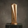 Trophée en cuivre givré à cinq branches avec un haut motif géométrique facetté, gravé avec les détails de la réalisation et présenté sur une base ronde et une plate-forme en marbre.