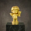 Figurine de mascotte ange en or tenant une petite coupe, présentant un joli personnage avec des ailes et un texte de base gravé, présenté sur une plate-forme en marbre.