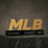 Trophée en forme de lettre MLB en or monté sur un socle noir avec texte chinois et anglais gravé, présenté sur une plateforme en marbre foncé.