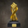 Trophée du championnat « Gold Peacekeeper Elite », doté d'un sommet en forme de caisse et d'un ruban au design dynamique, monté sur un socle noir avec une plaque gravée