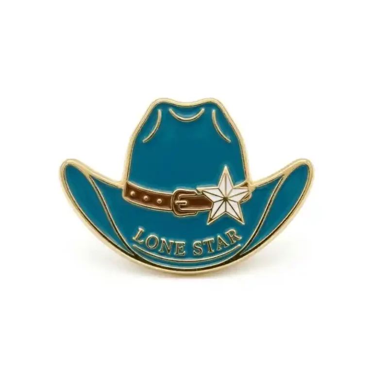 Turquoise cowboy hat enamel pin with gold outline, brown hatband, white star badge, and the text “Lone Star.”