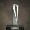 Trophée argenté givré à cinq branches avec un grand motif géométrique facetté, gravé avec les détails de la réalisation et présenté sur un socle en marbre foncé.