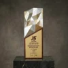 Trophée bicolore en aluminium aérospatial, argenté et doré, taillé dans le diamant, avec une base en bois de rose et une plaque gravée, présenté sur une plate-forme en marbre.