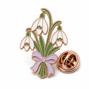 Bouquet Snowdrop Pin soft enamel pin with raised metal outlines, flat enamel color sections, connected badge details, and a butterfly clutch on a white background.