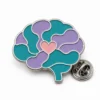 Calm brain neurodivergent pin with polished silver metal outlines, teal and lavender enamel sections, a connected heart inlay, and a butterfly clutch on white.