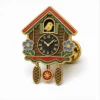 Bunte Kuckucksuhr-Anstecknadel aus weicher Emaille mit erhabenen Metallkonturen, flachen Emaille-Farbabschnitten, verbundenen Abzeichendetails und einem Schmetterlingsgriff auf weißem Hintergrund.