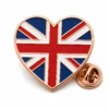 Heart flag Union Jack pin with rose gold metal outlines, red white and blue enamel bands, heart silhouette, and a butterfly clutch on white.