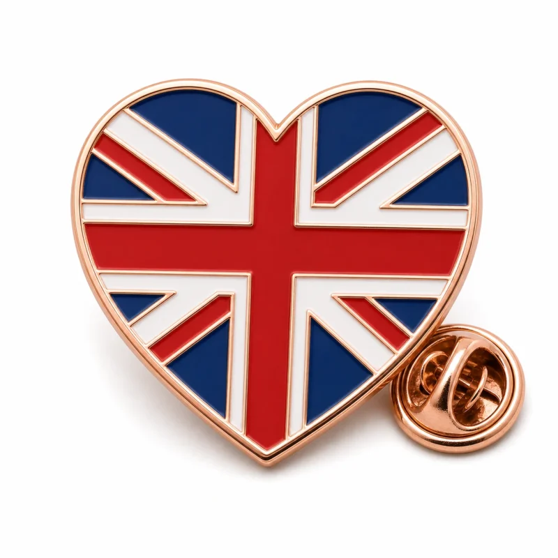 Heart flag Union Jack pin with rose gold metal outlines, red white and blue enamel bands, heart silhouette, and a butterfly clutch on white.