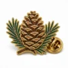 Needle Pine Cone Pin soft enamel pin with raised metal outlines, flat enamel color sections, connected badge details, and a butterfly clutch on a white background.