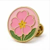 Pink Round Primrose Pin soft enamel pin with raised metal outlines, flat enamel color sections, connected badge details, and a butterfly clutch on a white background.