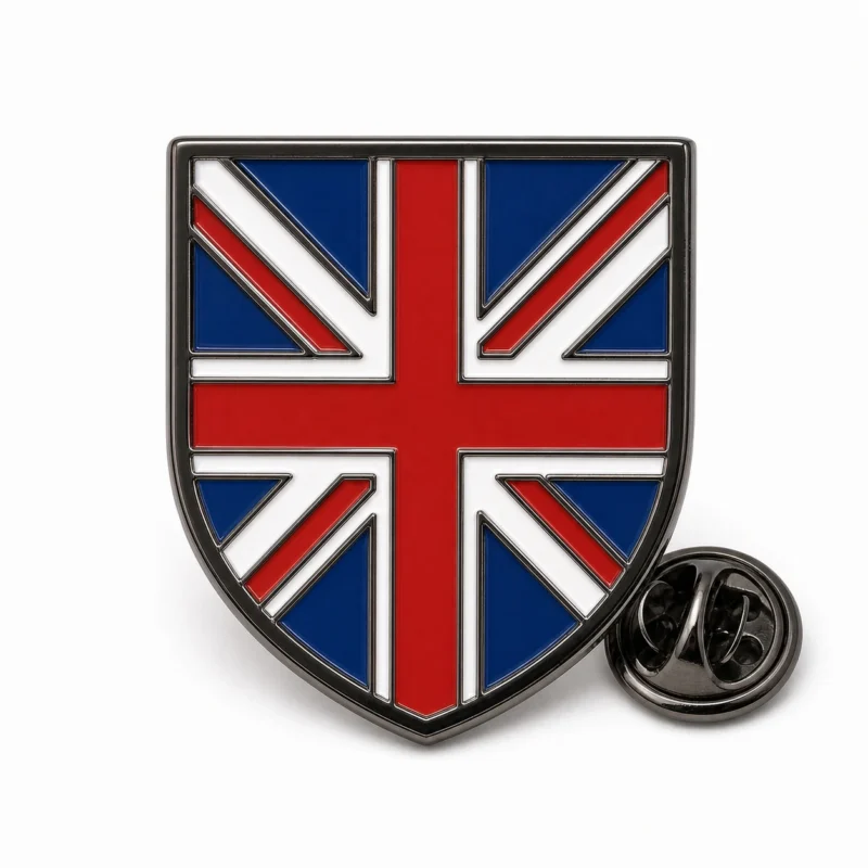 Shield flag Union Jack pin with black nickel outlines, red white and blue enamel flag pattern, shield badge shape, and a butterfly clutch on white.