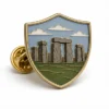 Shield Stonehenge Pin soft enamel pin with raised metal outlines, flat enamel color sections, connected badge details, and a butterfly clutch on a white background.