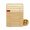 Vintage library card pin with raised gold metal outlines, cream enamel card body, tan divider rows, red stamp block, and a butterfly clutch on white.